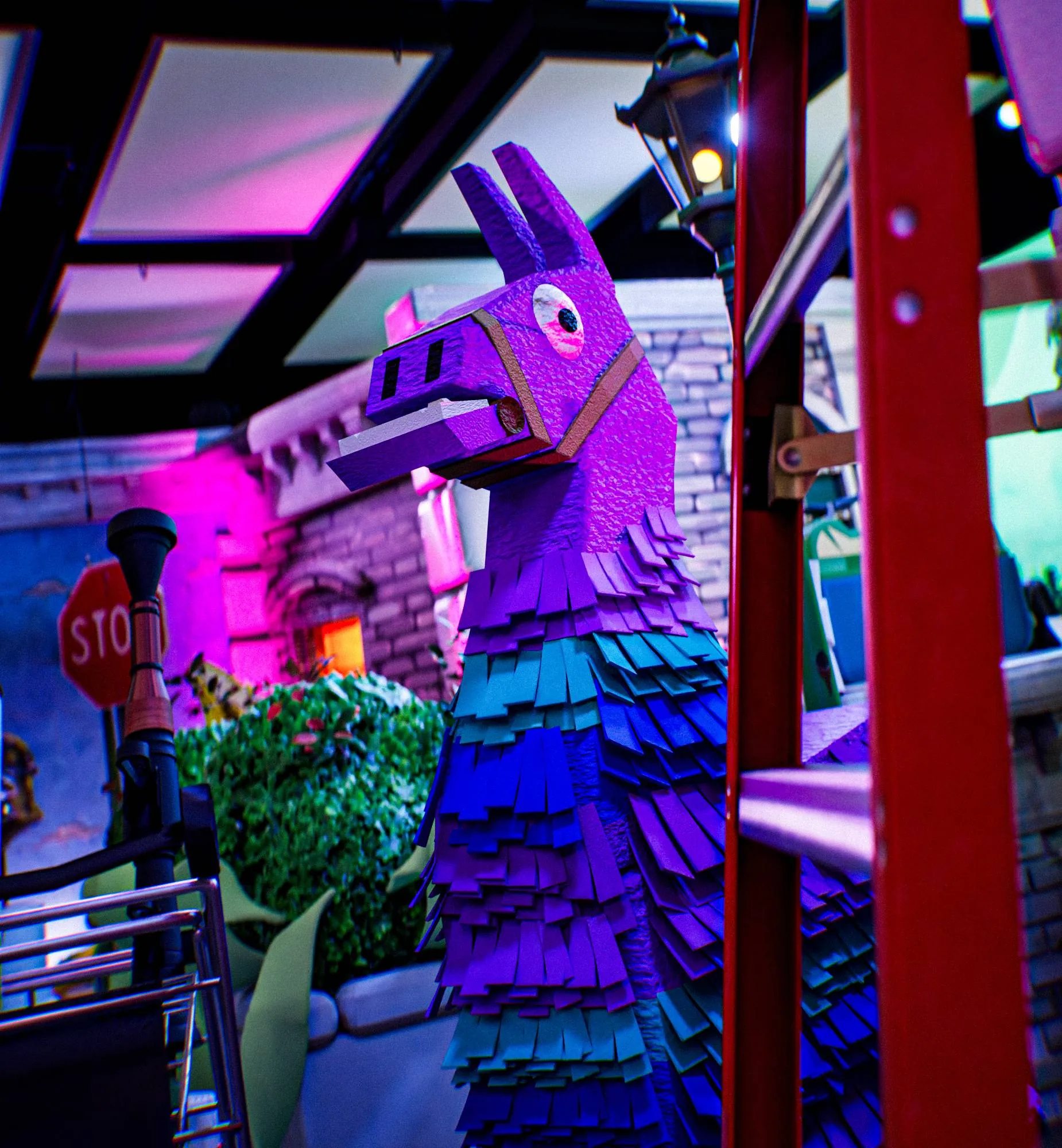 Fortnite’s purple and blue llama piñata, between a shopping cart and a red ladder.