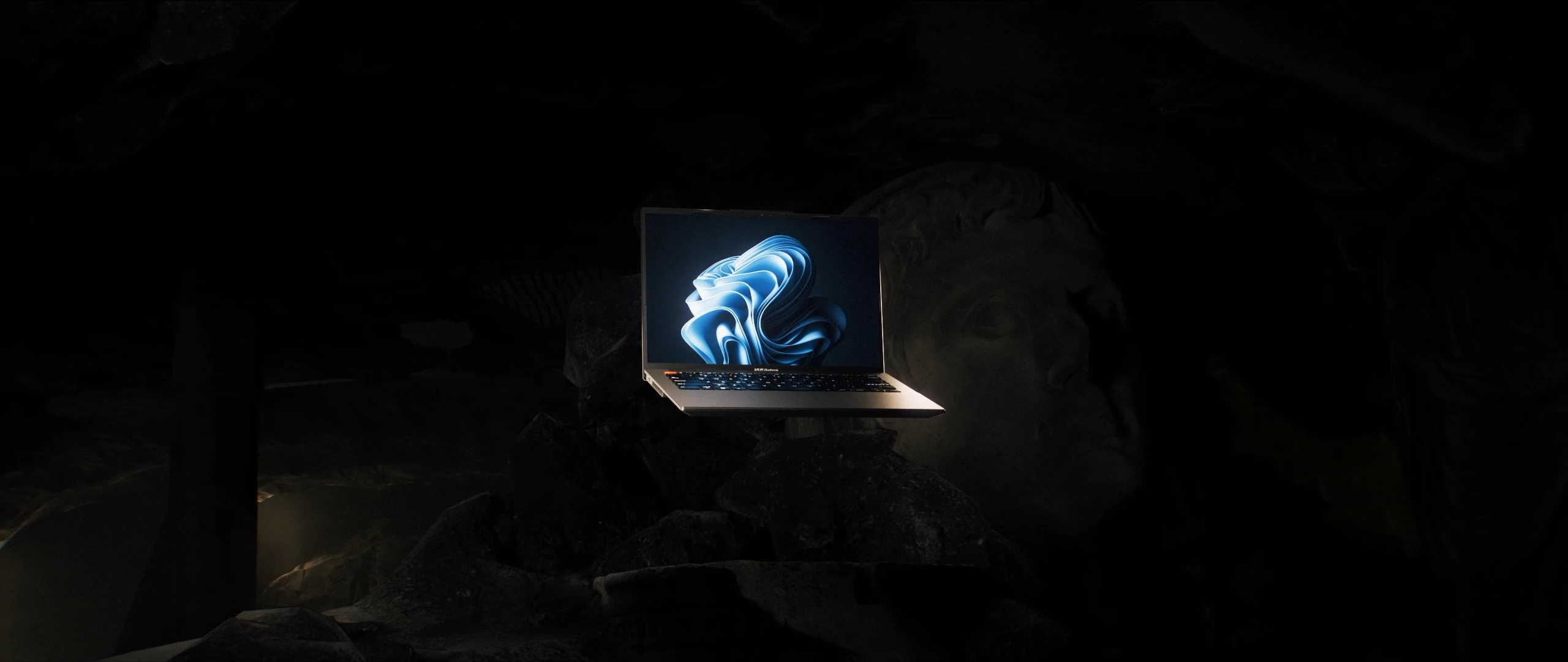 Le Vivobook éclairé au milieu du décor sculptural final.